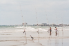 110904-1796 A Reddish Egret and humans fishing on the beach, Florida