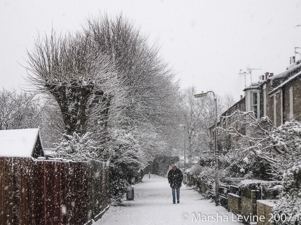 A man walking through the snow in Cambridge